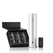 Silver Aroma diffuser with remote control next to a black box containing three bottles of hotel fragrances.