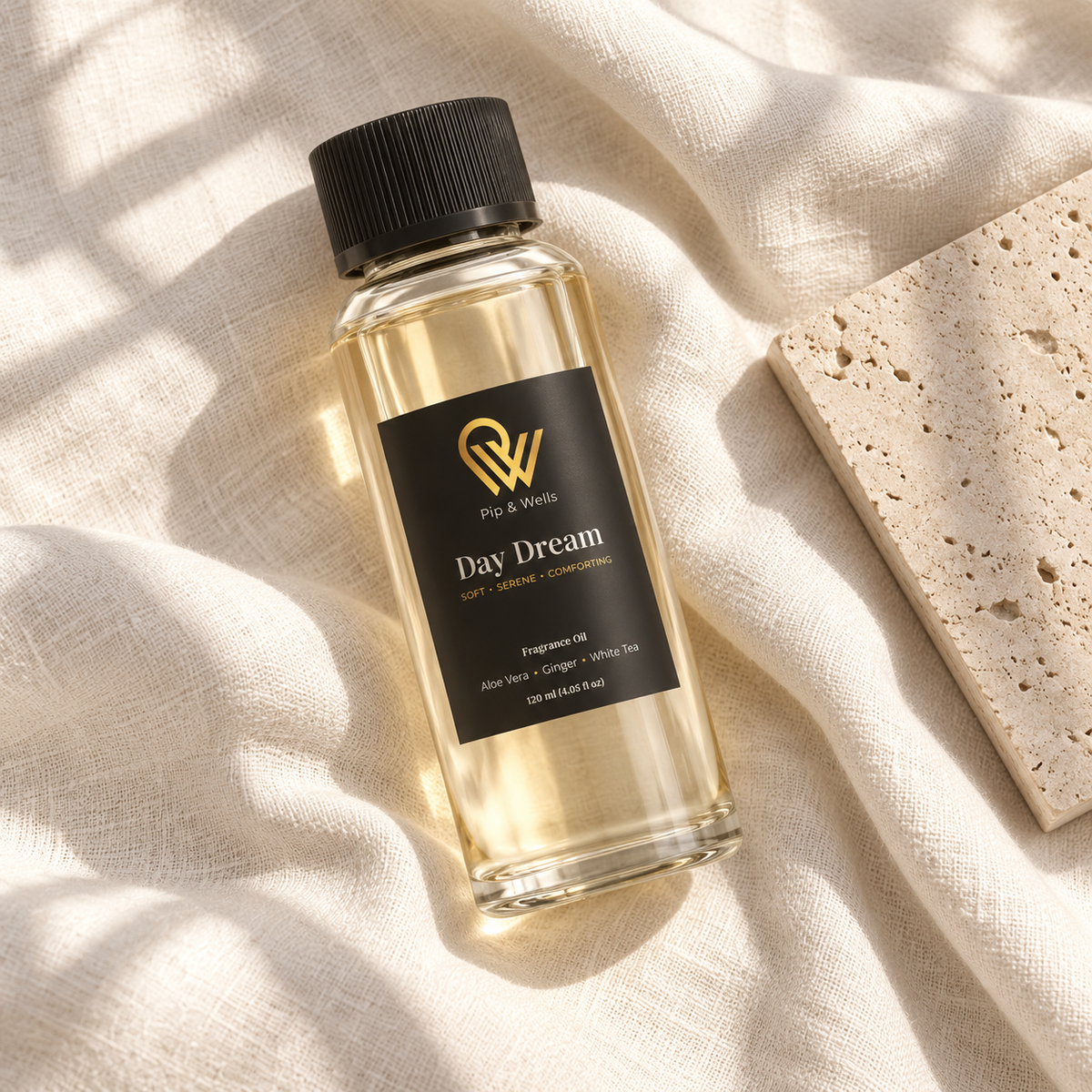Pip & Wells Day Dream 120 ml fragrance oil bottle on light linen beside a textured stone tile